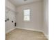 This laundry room has tile floors, a window, and a closet for storage at 722 Sandy Green Ct, Fort Mill, SC 29715