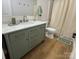 Well-lit bathroom with a green vanity, brushed gold hardware and a marble countertop at 1022 Johnna Ln, Indian Land, SC 29707