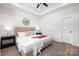 Well-lit bedroom featuring a stylish bed, two bedside tables, ceiling fan, and a round mirror on the wall at 1026 Dooley Dr, Charlotte, NC 28227