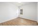 Bright, minimalist bedroom with a window offering natural light and a door leading to the hallway at 1026 Dooley Dr, Charlotte, NC 28227