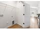 Spacious laundry area with wire shelving, utility connections, and a door to the hallway and front door at 1026 Dooley Dr, Charlotte, NC 28227