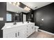 Bathroom with a white double sink vanity, framed mirror, and dark gray walls at 10914 Zac Hill Rd, Davidson, NC 28036