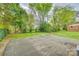 Large backyard area featuring mature trees and a paved parking pad at 110 Steele St # 34 35, Fort Mill, SC 29715