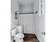 Compact bathroom featuring a toilet, sink, and shower with curtain and dark wood look vinyl flooring at 126 E Henderson St, Salisbury, NC 28144