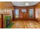 Spacious living room featuring warm wood paneling, three windows, and a vintage green-tiled fireplace at 126 E Henderson St, Salisbury, NC 28144
