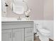 Modern half bathroom features a gray vanity with white countertop, round mirror, and a toilet with wainscoting at 1308 Spring Lake Dr, Gastonia, NC 28054