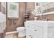 Well-lit bathroom featuring a white vanity, a decorative mirror, and a shower with a gray striped curtain at 1308 Spring Lake Dr, Gastonia, NC 28054
