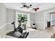 Bright exercise room featuring an exercise bike, weights, light wood floors, a fan, and a large window for natural light at 1308 Spring Lake Dr, Gastonia, NC 28054