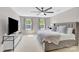 Neutral bedroom features a large bed with a cushioned headboard, two windows, a ceiling fan, and a television at 1308 Spring Lake Dr, Gastonia, NC 28054