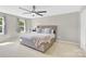 Neutral bedroom features a large bed with a cushioned headboard, two windows, and a ceiling fan at 1308 Spring Lake Dr, Gastonia, NC 28054