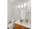 Clean bathroom with wood vanity, ample lighting, and a large mirror at 14802 Rolling Sky Dr, Charlotte, NC 28273