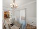 Dining room featuring a modern glass table, plush chairs, and elegant chandelier at 14802 Rolling Sky Dr, Charlotte, NC 28273