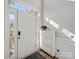 White front door and decorative white shoe cabinet in a bright entryway with light gray flooring at 14802 Rolling Sky Dr, Charlotte, NC 28273
