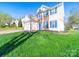 Two-story home with light siding, brick accents, and a large front yard with green grass at 14802 Rolling Sky Dr, Charlotte, NC 28273