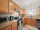 Bright kitchen features granite countertops, stainless steel appliances, and wood cabinets at 14802 Rolling Sky Dr, Charlotte, NC 28273