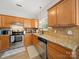 Well-lit kitchen features stainless steel appliances, granite countertops, and wood cabinets at 14802 Rolling Sky Dr, Charlotte, NC 28273