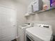 Functional laundry room features modern washer and dryer units and overhead shelving at 14802 Rolling Sky Dr, Charlotte, NC 28273