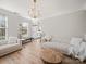Bright living room features light walls, modern chandelier, and stylish neutral furniture at 14802 Rolling Sky Dr, Charlotte, NC 28273