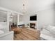 Inviting living room featuring fireplace, light gray walls and hardwood floors that lead to dining room at 14802 Rolling Sky Dr, Charlotte, NC 28273