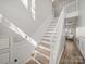 Elegant staircase with white railings and wood treads leads to the upper level at 14802 Rolling Sky Dr, Charlotte, NC 28273