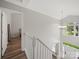 Bright staircase with white railings and hardwood floors offers a view of the entryway at 14802 Rolling Sky Dr, Charlotte, NC 28273