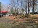 Exterior view of a home surrounded by mature trees and mulch, featuring a gravel parking area at 149 Deer Park Rd # D26/27, Mount Gilead, NC 27306