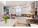 Stylish kitchen featuring white cabinetry, stainless steel appliances, and a vibrant backsplash at 1651 Duckworth Ave, Charlotte, NC 28208