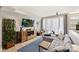 Modern living room with a stylish gray sofa, wooden entertainment center, and access to a balcony at 1651 Duckworth Ave, Charlotte, NC 28208