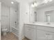 Bright bathroom with double sink vanity, tile floors, and a shower-tub combo with tiled walls at 2022 Puddle Pond Rd, Indian Trail, NC 28079