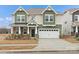 Charming two-story home with a two car garage, stone accents, green and beige color scheme, and a well-manicured lawn at 2022 Puddle Pond Rd, Indian Trail, NC 28079