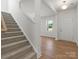 Inviting foyer features a staircase leading to the upper level and natural light streaming through a front window at 2022 Puddle Pond Rd, Indian Trail, NC 28079
