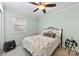 Inviting bedroom with a black metal frame bed, soft neutral bedding, and a ceiling fan for added comfort at 207 N Sims St, Kings Mountain, NC 28086