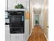 Long hallway leading into the home, adjacent to kitchen with double ovens and white cabinets at 207 N Sims St, Kings Mountain, NC 28086