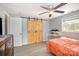 Large bedroom featuring a ceiling fan, wood look floors, a double barn door closet, and neutral paint at 217 Cedarhurst Ln, Clover, SC 29710