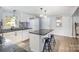 Bright kitchen featuring white cabinets, granite counters, black hardware, and a center island with bar stool seating at 217 Cedarhurst Ln, Clover, SC 29710