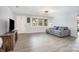 Bright living room features plank floors, a gray corduroy sofa, and a wooden television stand at 217 Cedarhurst Ln, Clover, SC 29710
