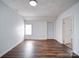 Bright room with laminate floors, featuring fresh paint and a bright light fixture at 2300 Kennesaw Dr, Charlotte, NC 28216