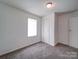 Bedroom featuring neutral carpet, a window, and a closet with a white door at 2300 Kennesaw Dr, Charlotte, NC 28216
