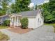 Charming house features a neatly maintained yard with a gravel driveway at 2300 Kennesaw Dr, Charlotte, NC 28216