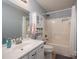 Bright bathroom with vanity, toilet, and shower-tub combination with storage and neutral color scheme at 2401 Gelsinger Ave, Bessemer City, NC 28016