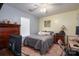 Well-furnished bedroom including a television, ceiling fan, desk, dresser, and a cozy gray bedspread at 2401 Gelsinger Ave, Bessemer City, NC 28016