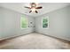 Bedroom features neutral carpet, two windows and ceiling fan at 2717 Stockwood Dr, Gastonia, NC 28056