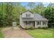 View of the home showing the driveway, siding, and a storage building on a landscaped lot at 2717 Stockwood Dr, Gastonia, NC 28056