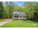 Charming two-story home featuring gray siding, black shutters, and a well-manicured lawn surrounded by lush trees at 2717 Stockwood Dr, Gastonia, NC 28056