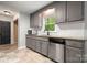 Well-lit kitchen features gray cabinets, granite countertops, and stainless steel dishwasher at 2717 Stockwood Dr, Gastonia, NC 28056