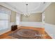 Formal dining room with hardwood floors, elegant chandelier, and classic wainscoting for sophisticated dining at 2740 Cameron Commons Way, Matthews, NC 28104