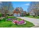 Charming two-story brick home featuring a two-car garage and beautifully landscaped front yard with vibrant flowers at 2740 Cameron Commons Way, Matthews, NC 28104