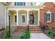 Inviting covered front porch with classic columns, brick steps and railing leading to the front door at 2740 Cameron Commons Way, Matthews, NC 28104