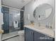 Hall bath with blue vanity and shower at 2740 Cameron Commons Way, Matthews, NC 28104