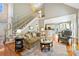 Open-concept living room flowing into kitchen, featuring a staircase, and hardwood floors throughout at 2740 Cameron Commons Way, Matthews, NC 28104